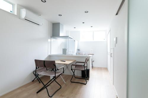 a kitchen with a table and chairs in a room at Suwa Tram Stay in Toyama