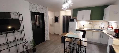 a kitchen with white cabinets and a black refrigerator at Horizon in Niort