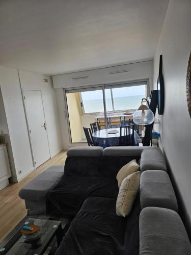 un salon avec un canapé et une table dans l'établissement Appartement Effet Mer, à Bernières-sur-Mer