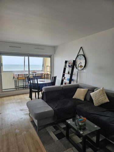 un salon avec un canapé et une table dans l'établissement Appartement Effet Mer, à Bernières-sur-Mer