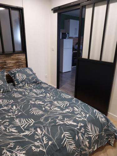 a bedroom with a bed with a black and white comforter at Horizon in Niort
