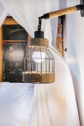 a cage light hanging from a curtain in a bedroom at Pensiunea Petra Verde in Porumbacu de Sus