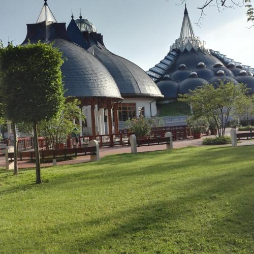 a building with domes on top of a grass field at Polár in Makó