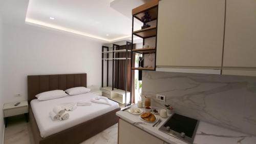 a small bedroom with a bed and a kitchen at Relax Apartments SB in Himare