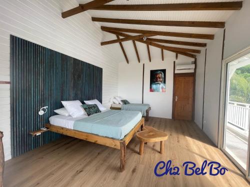 une chambre avec un lit et un parquet dans l'établissement Haut de villa BEL BO & Bas de villa Tibo accès mer, à Deshaies
