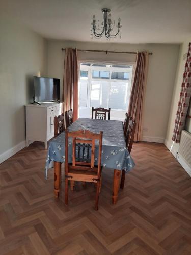 a dining room with a table and chairs and a television at Peggy's Place in Swinford