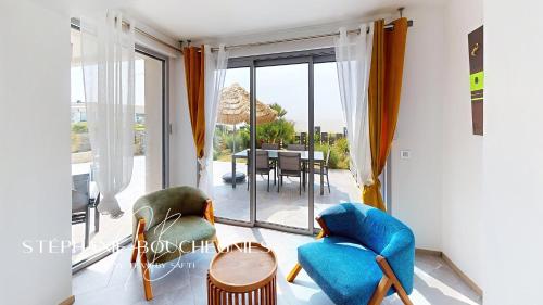 - un salon avec vue sur une table et des chaises dans l'établissement Villa Heure Bleue, à Saint-Georges-de-Didonne