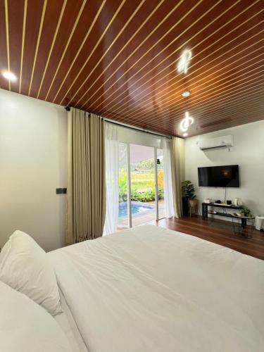 a bedroom with a large bed with a wooden ceiling at Nira Meraki Aruna in Bedoyo