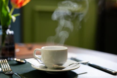 a cup of coffee on a table with a spoon at Casa D Hotel Napoli in Naples