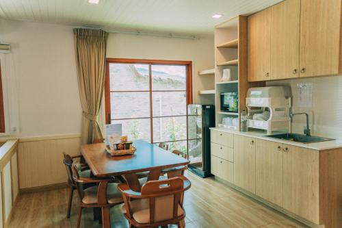 a kitchen with a table and chairs and a window at Khaoyai Art Tree in Pong Talong