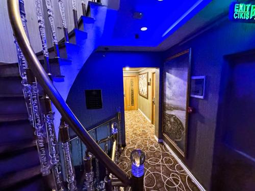 a person walking down a staircase with blue lights at Golden Sand Hotel in Istanbul