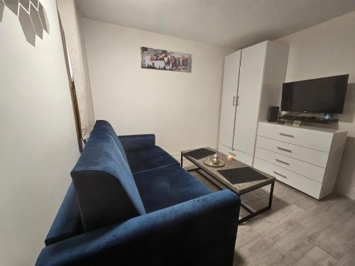 un salon avec un canapé bleu et une télévision dans l'établissement Studio très calme, à Paris