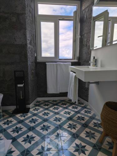 a bathroom with a sink and a counter and a floor at Cá Por Casa Pico-Criptoméria in Prainha de Baixo