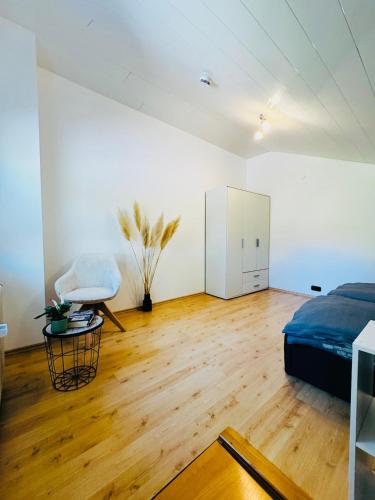 a bedroom with a bed and a chair in a room at Ferienwohnung Allgäuherz in Obergünzburg