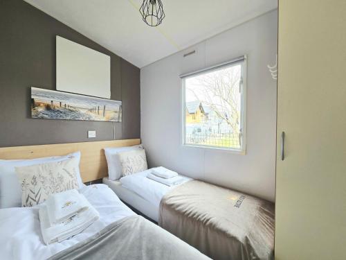 two beds in a small room with a window at Hollender Pool & Chill House Sarbinowo in Sarbinowo