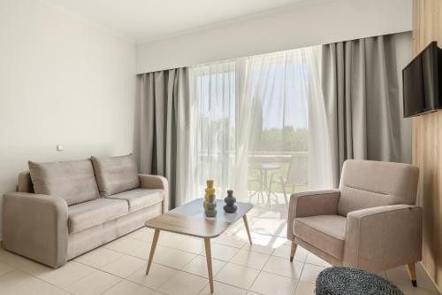 a living room with a couch and two chairs and a table at Kiotari Bay in Kiotari