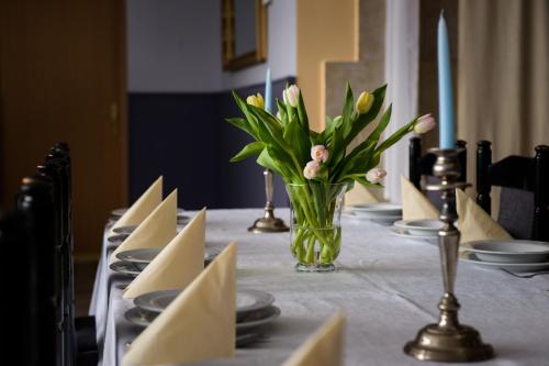 a table with a vase of flowers and napkins at Zajazd Saga in Gryfino