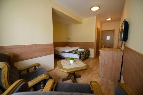 a hotel room with a bed and a table and chairs at Zajazd Saga in Gryfino