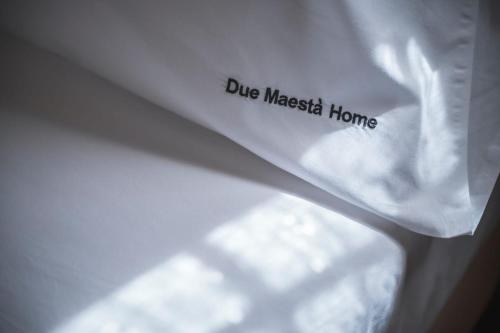 a white napkin with the words blue masked home on it at Due Maestà Home in Reggio Emilia