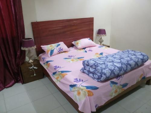 a bedroom with a bed with pink and blue sheets at S I Appartements in Dakar