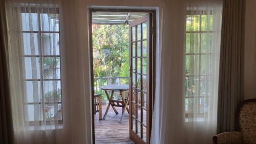an open door to a balcony with a table on the deck at Green Gables Guest House in Upington