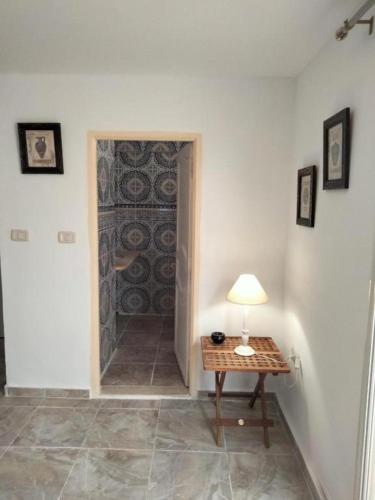 a room with a door with a table and a lamp at Studio Zitouna in Aghīr