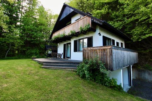 a small white house with a wooden roof at Ferienhaus Hadernigg in Hadernigg
