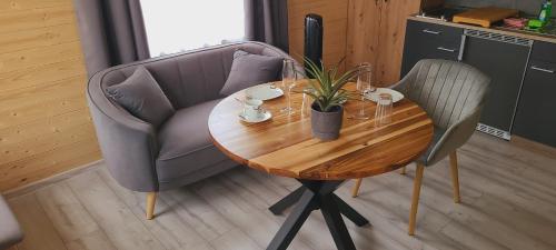 a wooden table with a chair and a table with a plant at Ferienwohnung Sylvia in Neustrelitz
