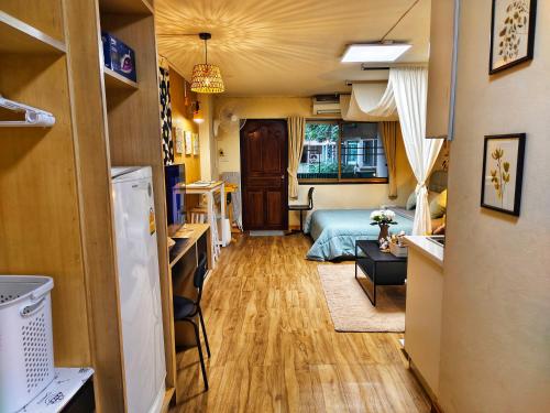 a room with a bed and a kitchen and a living room at Peaceful Condo at Happening Nimman in Chiang Mai