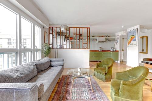 un salon avec un canapé, deux chaises et une table dans l'établissement Magnifique Appartement avec vue sur Tour Eiffel avec 3 chambres, à Paris