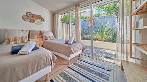 une chambre avec deux lits et une grande fenêtre dans l'établissement La Bohème-Close to St-Tropez Swimming pool -Tennis, à Saint-Tropez