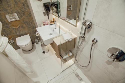 a bathroom with a shower and a sink and a toilet at La Quinta by Wyndham Batumi in Batumi