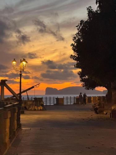a sunset on a beach with a street light at La Matrioska in Alghero