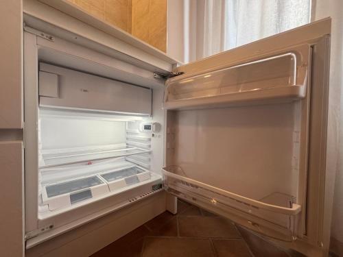 an empty refrigerator with its door open in a kitchen at Casa Arte in San Quirico dʼOrcia