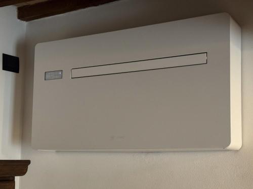 a white screen on a wall in a room at Casa Arte in San Quirico dʼOrcia