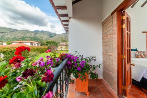 a balcony with red and purple flowers at Casa de las Flores in Villa de Leyva