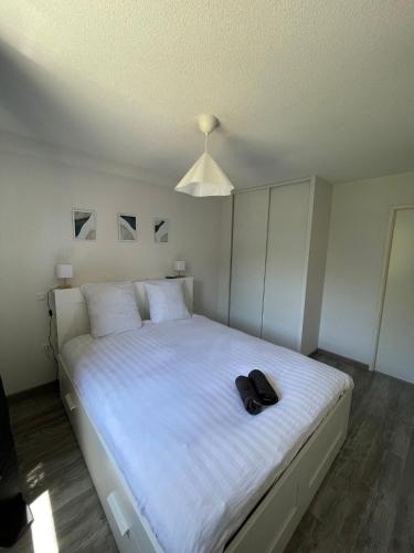 a bedroom with a white bed with a hat on it at Toulouse Coconing & Peaceful Apartment in Toulouse