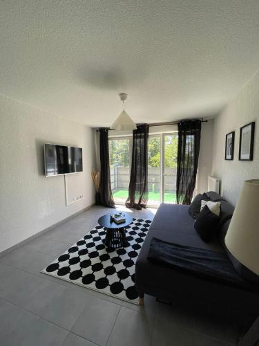 a living room with a couch and a checkered floor at Toulouse Coconing & Peaceful Apartment in Toulouse