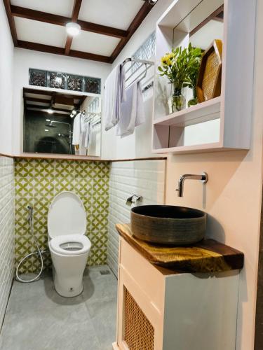 a bathroom with a toilet and a sink at Omah Jago Sentana Yogyakarta in Timuran