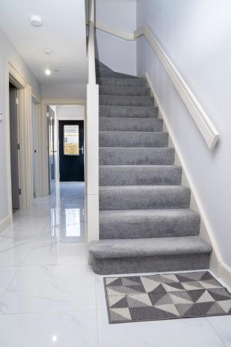a staircase in a house with a carpet at The Open 2025 Accommodation in Ballycastle