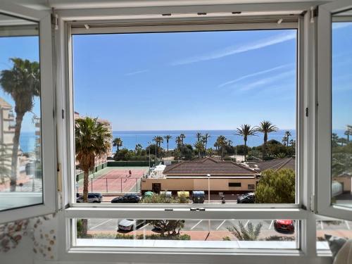 een raam met uitzicht op de oceaan vanuit de woonkamer bij The house of secrets in Torrevieja