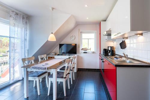 a kitchen with a table and chairs in a room at Arielle in Norddeich