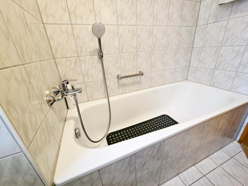 eine Badewanne mit Duschkopf im Bad in der Unterkunft Ferienland Sonnenwald Ferienwohnung 44 "Sonnenschein" in Langfurth 