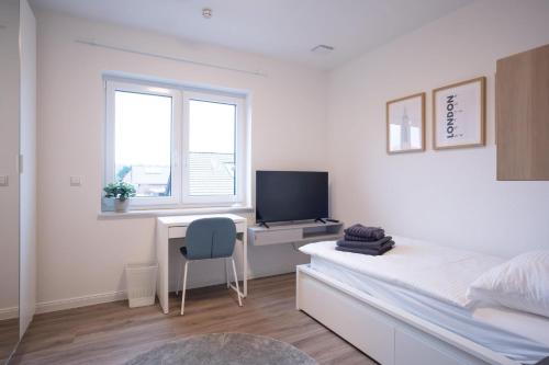 a bedroom with a desk and a bed and a tv at Wackenhuus 6 Albersdorf in Albersdorf