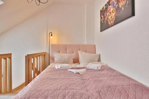 - une chambre avec un lit rose et 2 serviettes dans l'établissement Residenz Ostseestrand Appartement 31 "Aurora", à Scharbeutz
