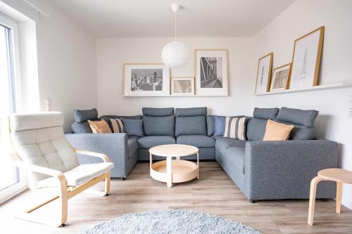 a living room with a blue couch and chairs at Wackenhuus 4 Albersdorf in Albersdorf