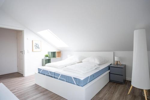 a white bedroom with a large bed in a room at Wackenhuus 4 Albersdorf in Albersdorf