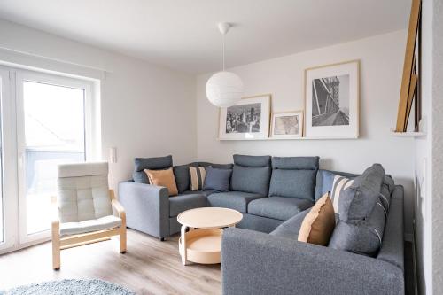 a living room with two blue couches and a table at Wackenhuus 4 Albersdorf in Albersdorf