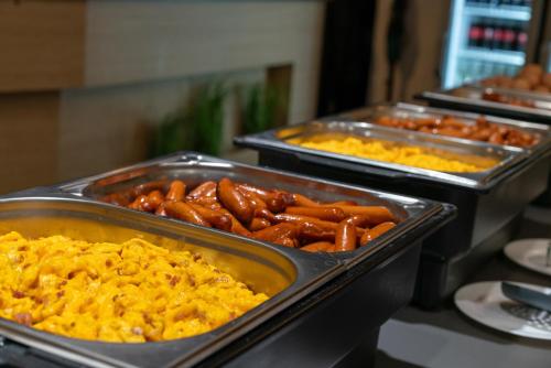 a buffet with trays of food on a table at Zafír Apartman Sárvár in Sárvár