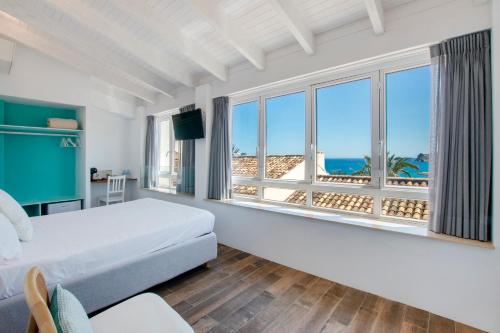 a bedroom with a bed and a view of the ocean at Hostal Perla Blanca Altea in Altea